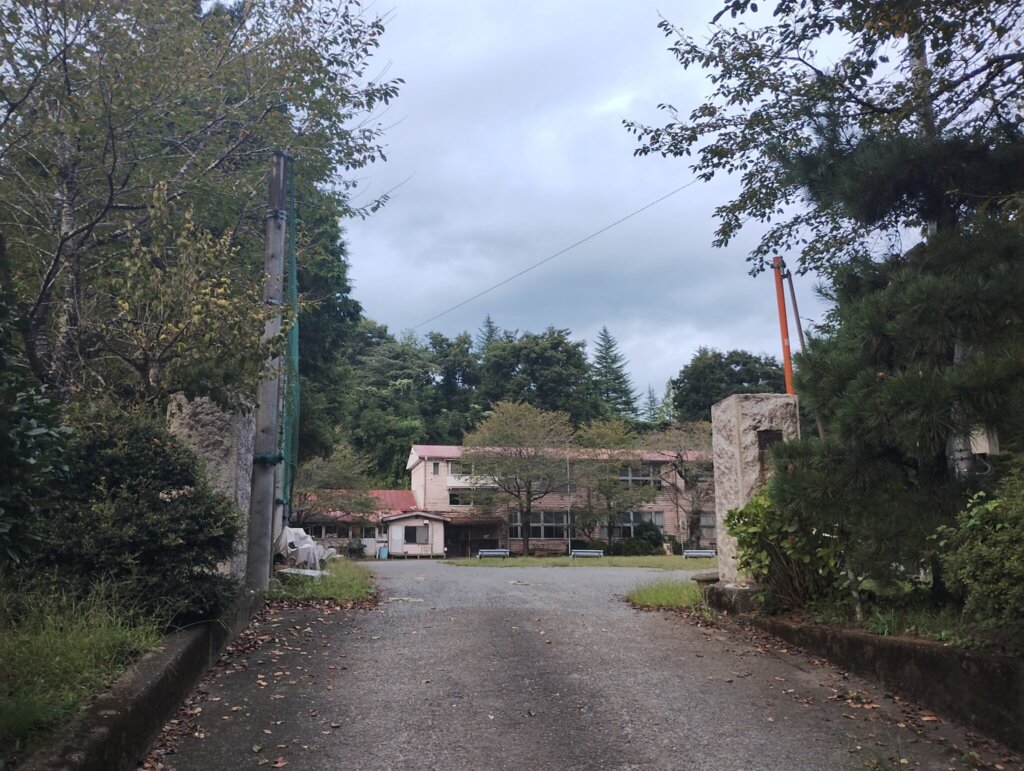 坂を登ったら校門越しに木造校舎発見。